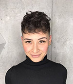 Front-facing headshot of Brianna Wiens, a woman with short dark hair and a smile, wearing a black turtleneck